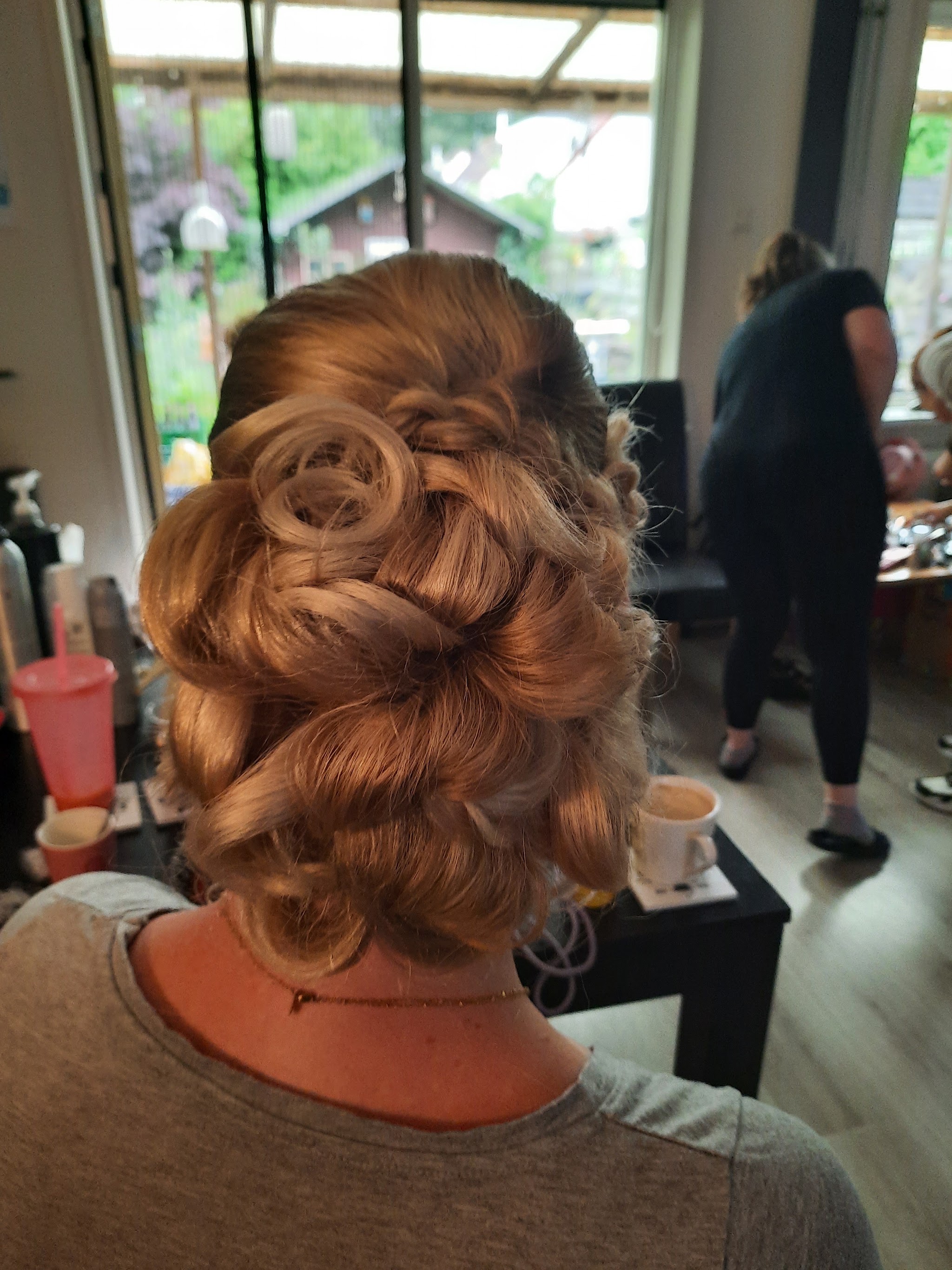 Roodbruin haar met een opgestoken kapsel en losse krullen, van achteren gezien